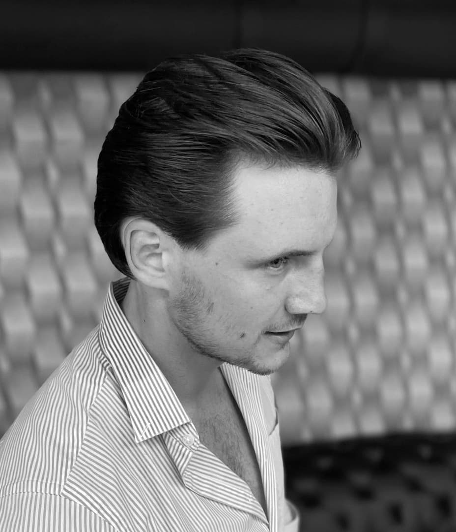 Men's haircut styled with volume and light stubble